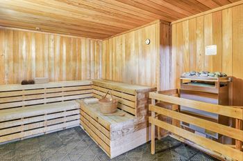 A wooden sauna with a bench and a table.